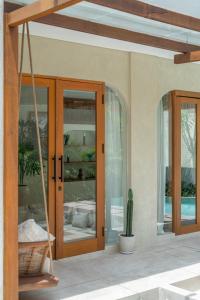 a porch with glass doors and a cactus at Alegria de la Vida in Canggu