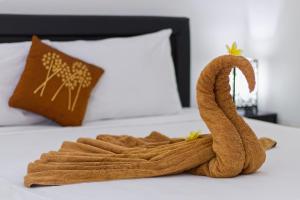 een handdoek is gemaakt om eruit te zien als een zwaan op een bed bij Ari La Casa in Nusa Penida
