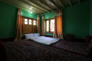 a green room with a bed and a window at OYO Flagship 4945 AR LODGE in Srinagar