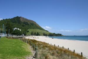 - une plage avec des personnes se promenant sur le sable et l'océan dans l'établissement Kereru Cottage , rural B&B, Tauranga, à Whakamarama