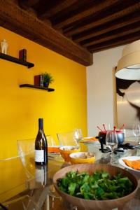 a table with a bottle of wine and a bowl of greens at Dijon La Belle Adresse in Dijon