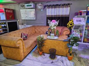 ein Wohnzimmer mit einem Sofa und einem Tisch mit Blumen in der Unterkunft Raja Hotel & Lodge - Kharagpur, West Bengal in Shyāmalpur