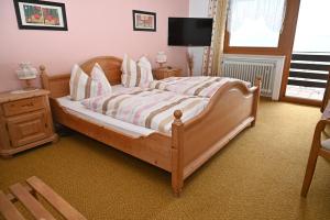 Un dormitorio con una gran cama de madera con almohadas en Pension Klein, en Bodenmais