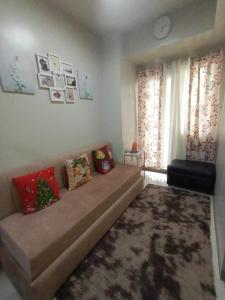 a living room with a couch and a window at Cozypura Staycation at S Residences Mall of Asia Complex Pasay City in Manila