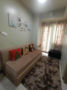 a living room with a brown couch in a room at Cozypura Staycation at S Residences Mall of Asia Complex Pasay City in Manila