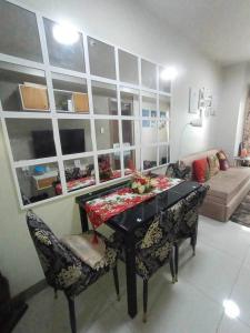 a living room with a table and chairs and a couch at Cozypura Staycation at S Residences Mall of Asia Complex Pasay City in Manila