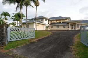 una puerta blanca frente a una casa con palmeras en Hilo Villa w/pool- 16 guests max, en Hilo