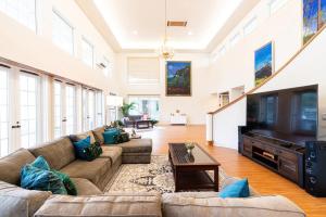 ein großes Wohnzimmer mit einem Sofa und einem TV in der Unterkunft Hilo Villa w/pool- 16 guests max in Hilo
