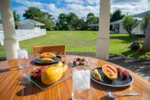 una mesa de madera con platos de fruta encima en Hilo Villa w/pool- 16 guests max, en Hilo