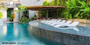 a row of white chairs sitting in a pool at Son&Henry Zenity District 1 in Ho Chi Minh City