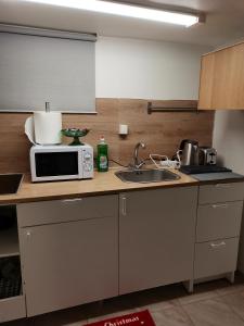 a kitchen with a microwave and a sink at Keflavik Cozy Apartment in Keflavík