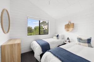 Paihia Coastal 2 Bedroom Cottages tesisinde bir odada yatak veya yataklar