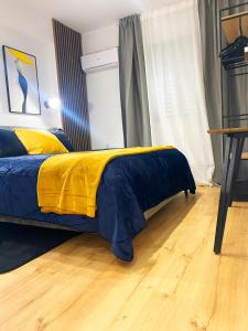 um quarto com uma cama com um cobertor amarelo e azul em Luxury City Retreat- 2-Bedroom, 2-Bath Apartment em Nicósia