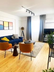 uma sala de estar com um sofá azul e cadeiras em Luxury City Retreat- 2-Bedroom, 2-Bath Apartment em Nicósia