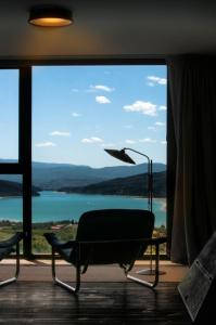 a chair in front of a large window with a view at Casa Boumort in Sant Marti de Canals