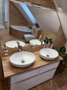 une salle de bains avec trois lavabos sur un comptoir en bois dans l'établissement Dom z widokiem na jezioro, à Chrostkowo