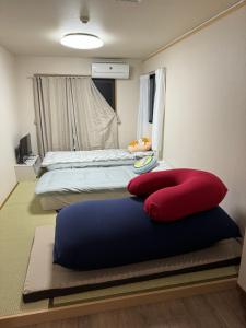 a bedroom with two beds with red and blue pillows at 水之道 in Osaka