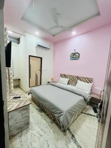 a bedroom with a large bed and a pink wall at HOTEL S S PALACE in Agra