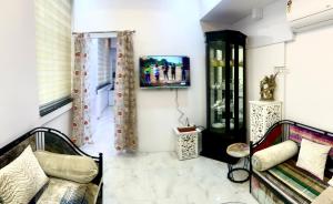 a living room with a couch and a tv at Cozy 1 BHK Apartment in Nagpur
