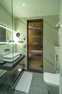 a bathroom with a sink and a toilet and a shower at Regenta Inn Bhavani Nellore By Royal Orchid Hotels in Nellore