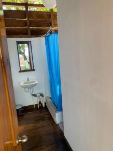 baño con lavabo, espejo y cortinas azules en Casa GaNiMo - propiedad privada, frente al mar, en La Libertad