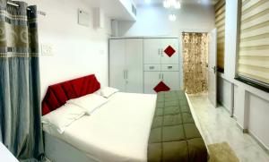a bedroom with a large bed with a red headboard at Cozy 1 BHK Apartment in Nagpur