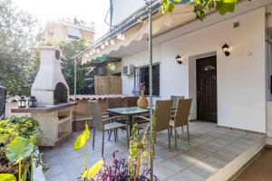 a patio with a table and chairs and a pizza oven at Nagias cozy garden home in Athens