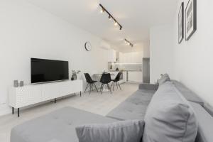 a living room with a couch and a flat screen tv at Apartment with Balcony by the Park in Łódź by Renters Prestige in Łódź
