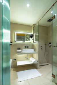 a bathroom with a sink and a shower at Regenta Inn Bhavani Nellore By Royal Orchid Hotels in Nellore +36 photos
