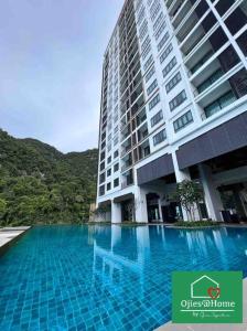淡文Ojieshome 1BR Sunway Onsen Tambun的一座前面有游泳池的大楼