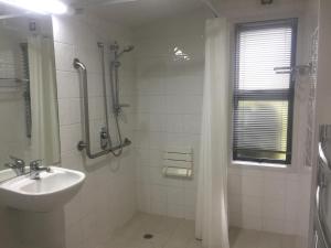 a white bathroom with a sink and a shower at Hanmer Garden Suites in Hanmer Springs