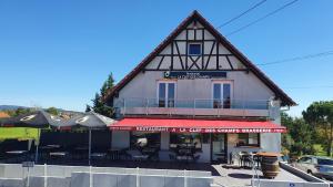 ein Gebäude mit Tischen und Stühlen davor in der Unterkunft Résidence La Clef des Champs in Morsbronn-les-Bains