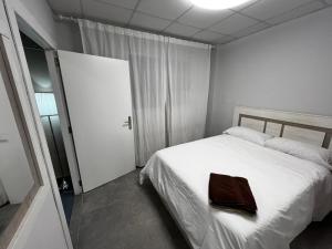 Un dormitorio con una cama blanca con una toalla marrón. en RMN TOURIST HOME, en Valencia