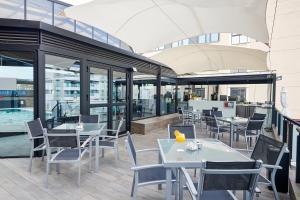 a restaurant with tables and chairs and a pool at Gran Hotel Luna de Granada in Granada