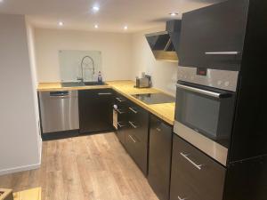 a kitchen with stainless steel appliances and wooden floors at Dhrontalstube in Gräfendhron