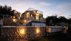 Villelia View Villas 2 في Apolpaina: منزل كبير مع أضواء على جدار حجري