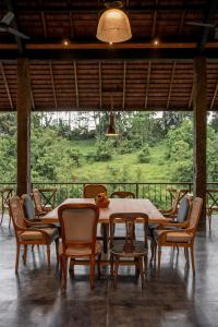 a dining room table and chairs with a view of a field at Bedulu Cliff Estate Villas Complex Ubud in Ubud