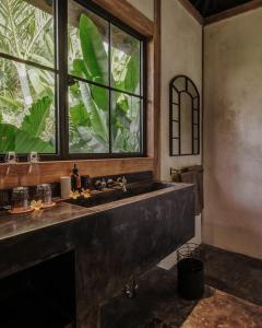 a bathroom with a large sink and a window at Bedulu Cliff Estate Villas Complex Ubud in Ubud