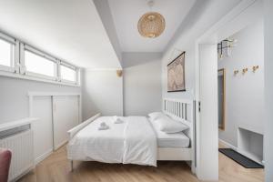 a white bedroom with a bed and a window at Nowy Świat 22 Luxury Apartment in Warsaw