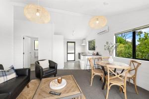 a living room with a table and chairs at Paihia Coastal 2 Bedroom Cottages in Haruru