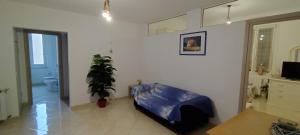 a living room with a bed and a potted plant at Stella Marina - voglia di vacanza e di relax in Genova