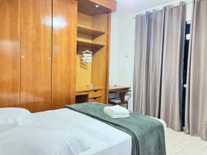 - une chambre avec un lit et une armoire en bois dans l'établissement Cobertura com piscina em Cabo Frio, à Cabo Frio