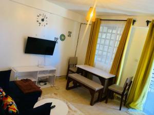 a living room with a couch and a table and a desk at Rorot 1 bedroom Kapsoya with free wifi and great views! in Eldoret