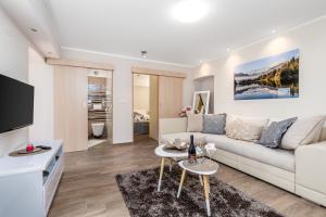 a living room with a white couch and a tv at Apartment Srok, Relax in Kastav