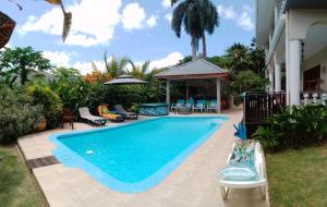 a swimming pool in the backyard of a house at Royal Bay Apartment in Anse Royale