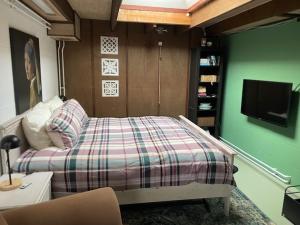 um quarto com uma cama e uma televisão de ecrã plano em Aan de Dijk em Dordrecht