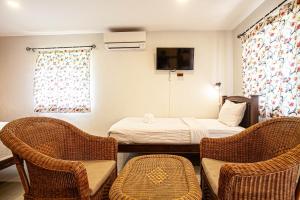 a small room with a bed and two chairs at Lanta Thai Homestay in Ko Lanta