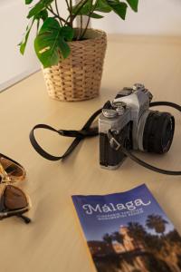 una macchina fotografica seduta su un tavolo accanto a una rivista di Larios Premium Apartments a Málaga