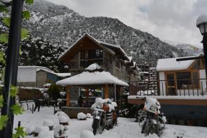 two motorcycles parked in front of a house covered in snow at Utopia Dharamkot Mcleodganj in Dharamshala