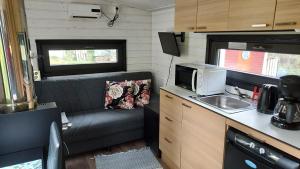 a kitchen with a couch and a sink in an rv at Minicabin in Vuokatti